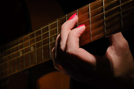 female hand with guitar strings plays closeupの写真素材