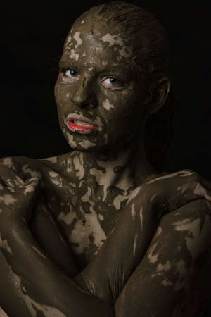 fun woman with black dirty smeared make up on black background