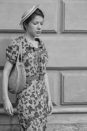 fashion style portrait. Young elegant woman in long dress posing at old city building monochrome