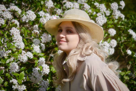 beautiful young woman near rhododendron blossoms close up portrait