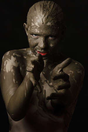 fun woman with black dirty smeared make up on black background