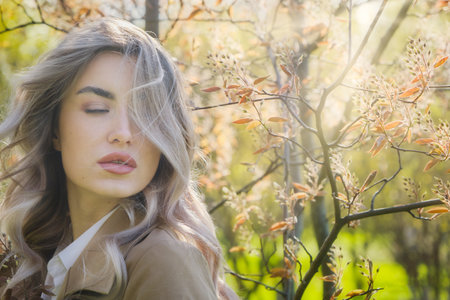 Pretty blond woman in blossom spring gardenの写真素材