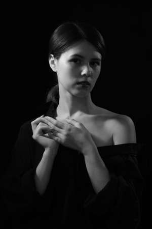 sensual serious woman in multicolor lights on black background posing at studio monochromeの写真素材