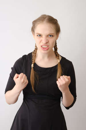 The young emotional angry woman screaming on white studio background
