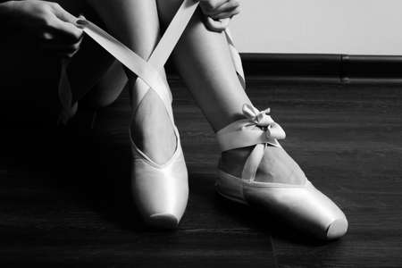 female ballerina feet with pointes on a wooden floor closeup image, monochromeの写真素材