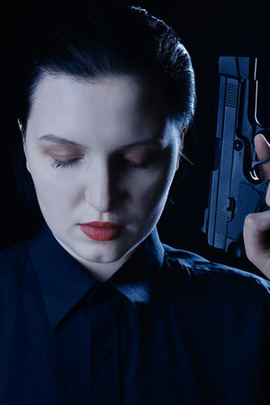 female portrait with gun closeup on black background closeup front view