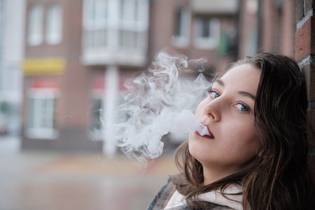 young woman on city street exhale smoke closeup portrait