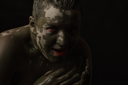 fun woman with black dirty smeared make up on black backgroundの写真素材