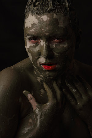 fun woman with black dirty smeared make up on black backgroundの写真素材