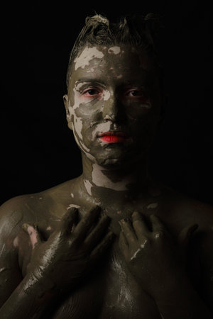 fun woman with black dirty smeared make up on black backgroundの写真素材