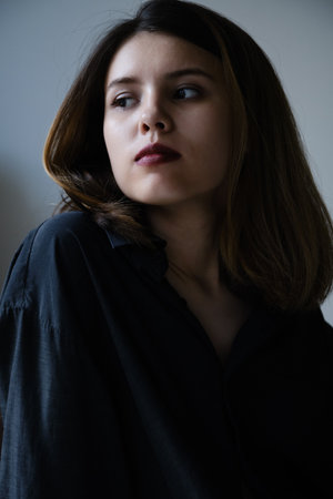 beautiful young serious woman in blouse on black backgroundの写真素材
