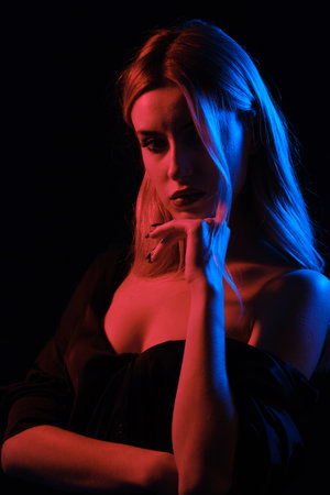 sensual young blond woman with bare shoulders on black background