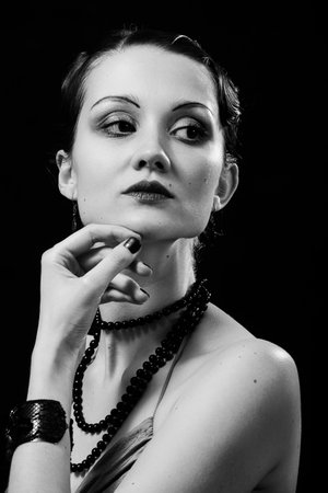 Young woman posing sensually looking aside on black backgroundの写真素材