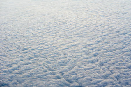 Clouds, sun, sky as seen through window of an aircraftの写真素材