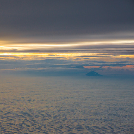 Clouds, sun, sky as seen through window of an aircraftの写真素材