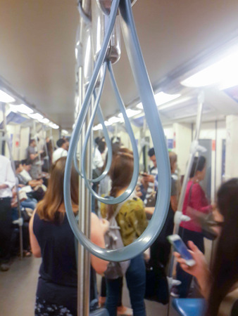 handle on a train and many people blurred backgroundの写真素材