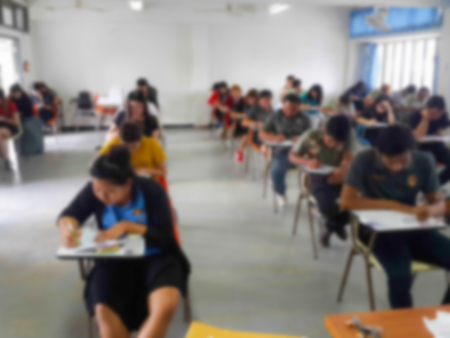 Blur school background university students writing answer doing exam in classroomの写真素材