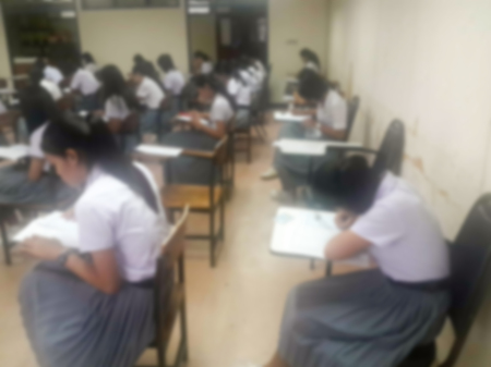 Blur background university students writing answer doing exam in classroom, view from back of the classの写真素材