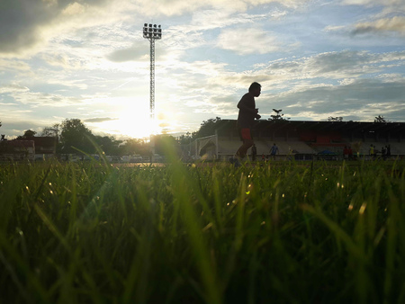 Silhouette  running on road at sunrise. Fitness and workout wellness concept.の写真素材