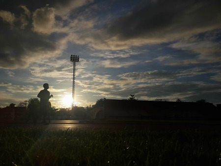Silhouette  running on road at sunrise. Fitness and workout wellness concept.の写真素材
