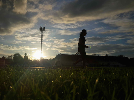 Silhouette  running on road at sunrise. Fitness and workout wellness concept.の写真素材