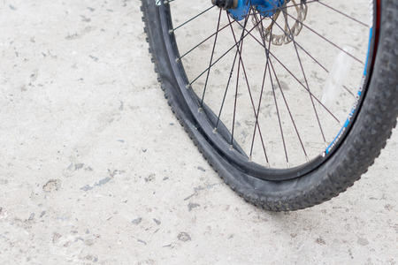 Closeup view of bicycle flat tire on pavement.の写真素材