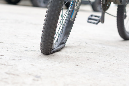 Closeup view of bicycle flat tire on pavement.