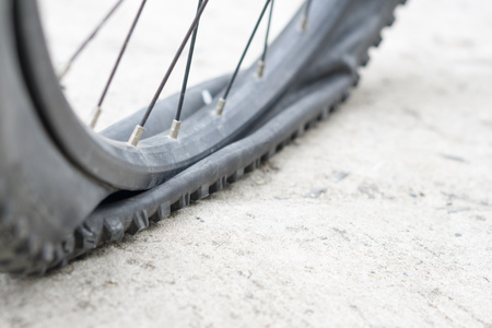 Closeup view of bicycle flat tire on pavement.の写真素材