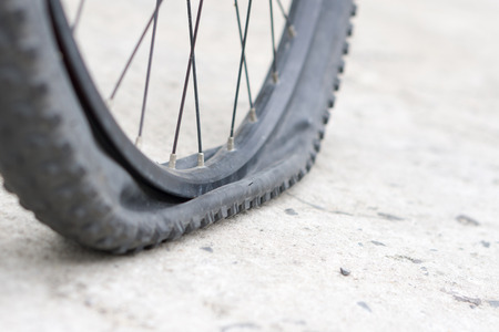 Closeup view of bicycle flat tire on pavement.の写真素材