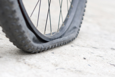 Closeup view of bicycle flat tire on pavement.の写真素材