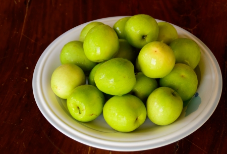 fresh chinese jujube in white plate on wooden backgroundの写真素材