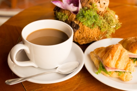 morning breakfast - coffee and croissant sandwish on restaurant tableの写真素材