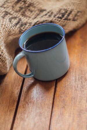 enamel mug on wood and sack bag backgroundの写真素材