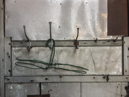 Old metal door with a green wire on it, close-upの写真素材
