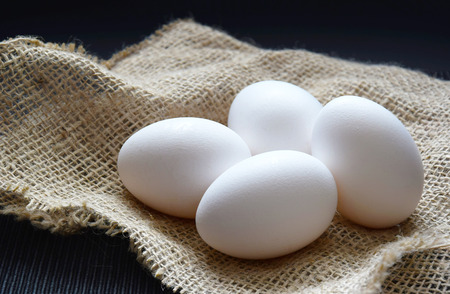  white eggs on a sack  on back table blackground