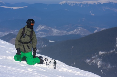 The snowboarder-freerider is sitting on the brink of a precipice.のeditorial素材