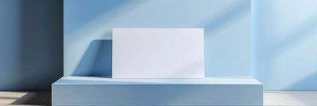 Minimalist scene with blank white poster on blue wallの素材
