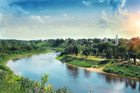 red church with blue domes from Rzhev town on the shore surrounded by green trees, view from Volga river at sunny summer dayの写真素材