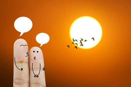 Couple finger holding flower on sunset or sunlight backgroundの写真素材