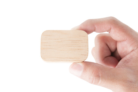 Hand holding a wooden block on white backgroundの写真素材