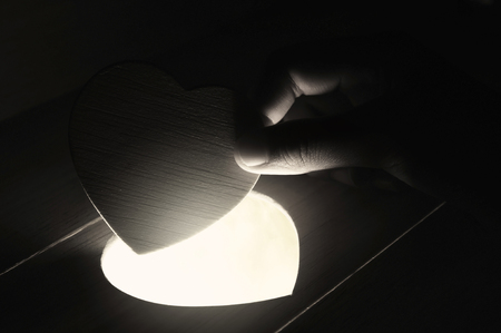Hand open wooden heart shape , holiday abstract backgroundの写真素材