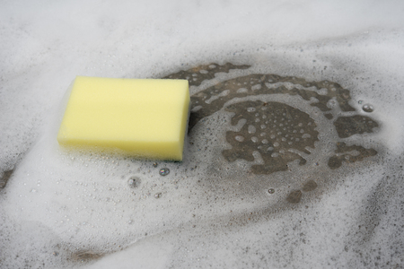 Sponge with white bubble foam soap sud washing and cleaning on concrete floor , home work house holdの写真素材
