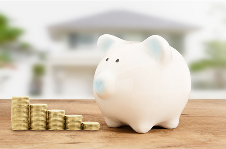 Piggy bank  and gold coin on wood with home background , saving banking ,family conceptの写真素材