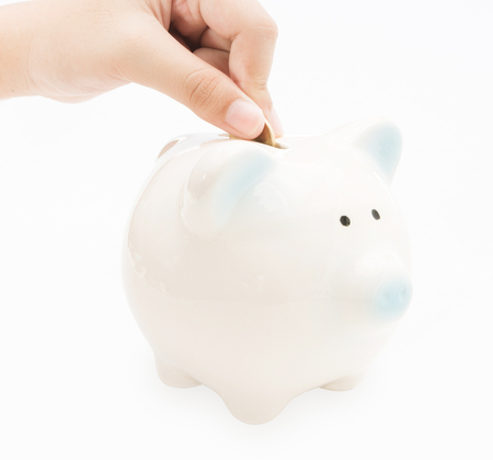Hand putting coin into piggy bank on white background , saving banking ,family conceptの写真素材