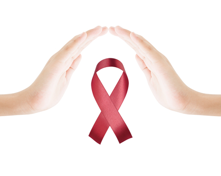 Two hands female protect red ribbon on white background sign of world aids day hiv , 1 december symbol of health cancer dayの写真素材