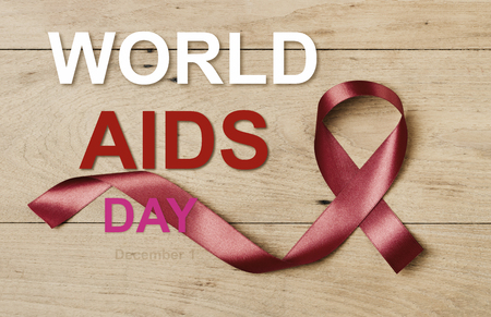 Red ribbon on wood table and text world aids day 1 decemberの写真素材
