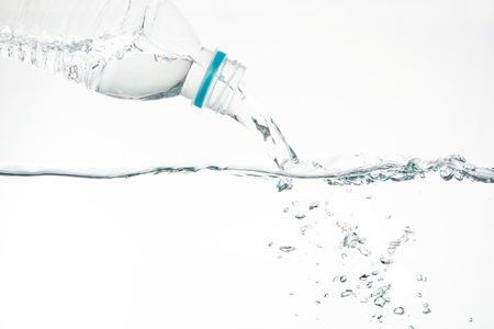 Water pouring from water bottle on white backgroundの写真素材