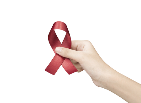 Hand of women holding red ribbon on white background sign of world aids day hiv , 1 december symbol of health cancer dayの写真素材