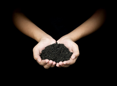 Hands of women holding soil in nature on dark black background 5 december world soil day ecology growth conceptの写真素材