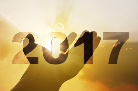Hand on sunset background with text 2017 celebration christmas happy new year art abstract backgroundの写真素材